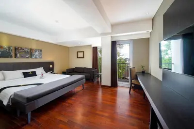 a bedroom with a large bed and a living room at Brits Hotel Legian in Seminyak