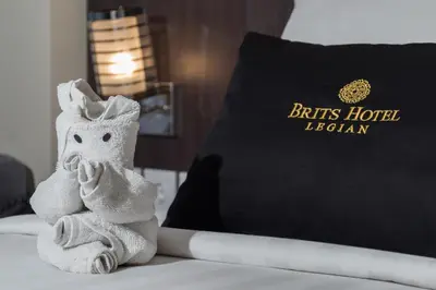 a towel animal sitting on a bed with a pillow at Brits Hotel Legian in Seminyak