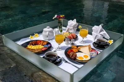 a tray of breakfast foods and drinks on a table at Villa Reina by SooBali - Spacious & Modern near Canggu with Butler-Cook, Private Pool and Tropical Gardens in Kerobokan