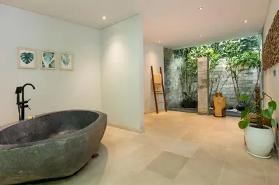 a bathroom with a large stone tub in a room at Villa Reina by SooBali - Spacious & Modern near Canggu with Butler-Cook, Private Pool and Tropical Gardens in Kerobokan