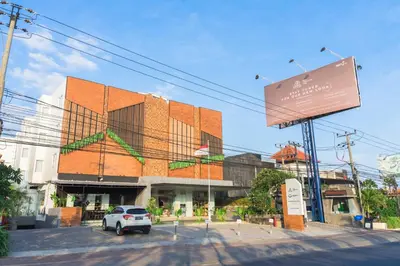 a building with a car parked in front of it at Berry Biz Hotel Sunset Road in Seminyak