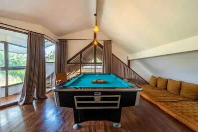 a pool table in a living room with a couch at Villa Tarita Canggu in Kerobokan