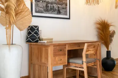 a wooden desk with a chair and a vase at Villa Tarita Canggu in Kerobokan