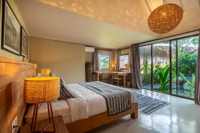 a bedroom with a bed and a large window at Villa Tarita Canggu in Kerobokan
