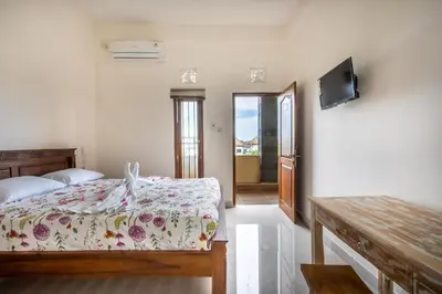 a bedroom with a bed and a flat screen tv at Lavanda guesthouse/homestay in Jimbaran
