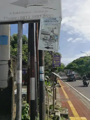 a sign for a bus stop on the side of a street at Lavanda guesthouse/homestay in Jimbaran