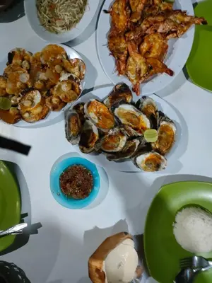 a table with plates of seafood and other food at Lavanda guesthouse/homestay in Jimbaran