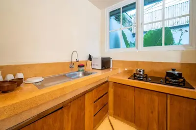 a kitchen with a sink and a stove and a window at Villa Panchajanya - Seminyak in Seminyak