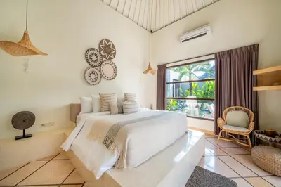 a bedroom with a bed and a large window at Villa Panchajanya - Seminyak in Seminyak