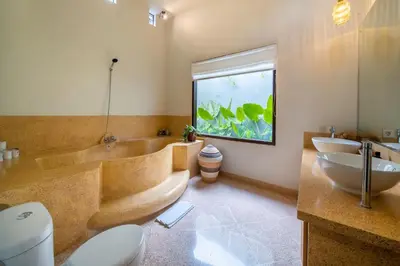 a bathroom with a tub and a toilet and a fish tank at Villa Panchajanya - Seminyak in Seminyak