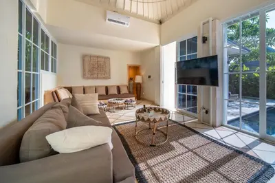 a living room with a couch and a tv at Villa Panchajanya - Seminyak in Seminyak