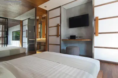 a bedroom with a bed and a tv on a wall at 8BR Villa Jumis - Minggu Villas Seminyak in Seminyak