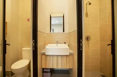 a bathroom with a sink and a toilet and a mirror at K Hostel Seminyak in Seminyak