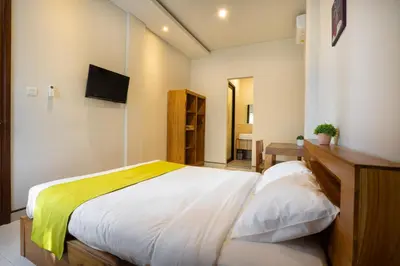 a bedroom with a bed and a television in it at K Hostel Seminyak in Seminyak