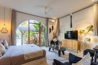 a bedroom with a bed and a tv in a room at Villa Lagertha by Optimum Bali Villas in Kerobokan