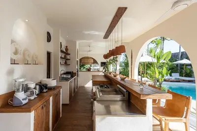 an open kitchen with a pool in the background at Villa Lagertha by Optimum Bali Villas in Kerobokan