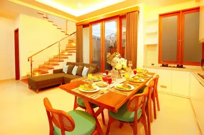 a dining room with a wooden table and chairs at Villa Noam By Bali Asia Villa in Jimbaran