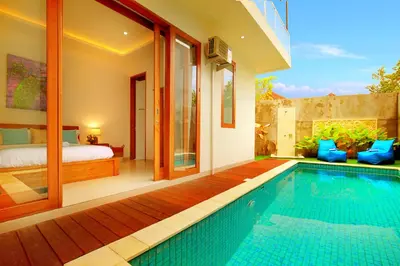 a villa with a swimming pool and a bedroom at Villa Noam By Bali Asia Villa in Jimbaran