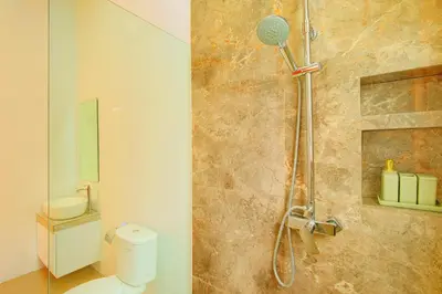a bathroom with a shower with a toilet and a sink at Villa Noam By Bali Asia Villa in Jimbaran