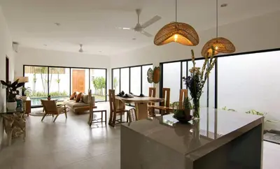 a kitchen and living room with a table and chairs at VILLA NIKOLE in Seminyak