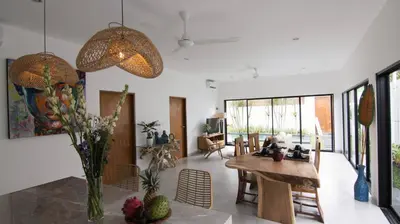 a living room with a table and a dining room at VILLA NIKOLE in Seminyak