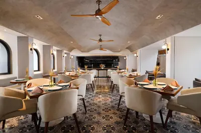 a restaurant with tables and chairs and a ceiling at The Mahata in Legian