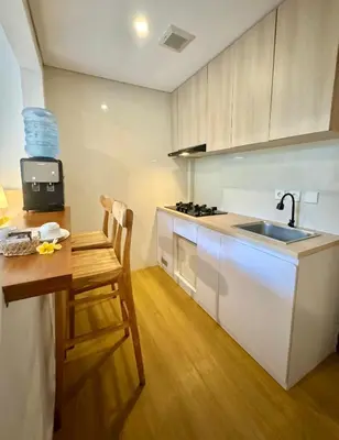a kitchen with a sink and a counter with a chair at The Hita Apartement in Seminyak