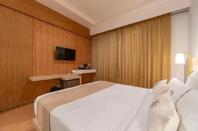 a hotel room with a bed and a tv at The Hita Apartement in Seminyak