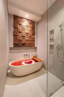 a bath tub in a bathroom with a shower at The Hita Apartement in Seminyak