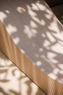 a close up of the back of a chair with a shadow at Donguri House Bali in Jimbaran