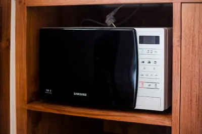 a microwave oven sitting on a wooden shelf at Donguri House Bali in Jimbaran