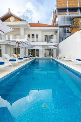 a swimming pool with chairs and a building at Luxury minimalist villa White Angel in Seminyak, sleeps 21 people in total in Seminyak