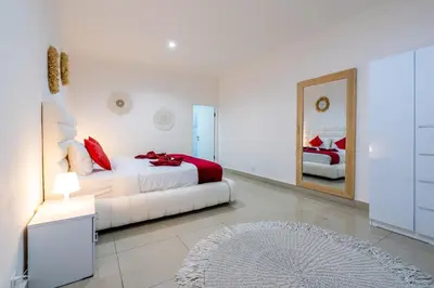 a white bedroom with a bed and a mirror at Luxury minimalist villa White Angel in Seminyak, sleeps 21 people in total in Seminyak