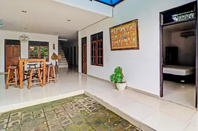 a kitchen and living room with a table and chairs at Capital O 92094 Hotel Kertha in Pesanggaran
