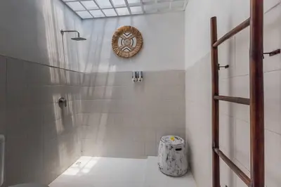 a bathroom with a shower with a clock on the wall at Central & Charming 3bedr with private pool in Seminyak
