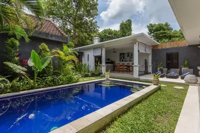 a house with a blue swimming pool in front of a house at Central & Charming 3bedr with private pool in Seminyak