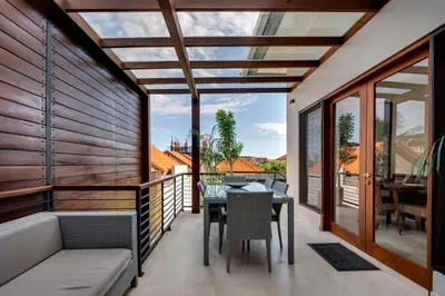 a patio with a table and chairs on a balcony at Malinda Villa Seminyak in Seminyak