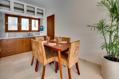 a dining room with a wooden table and chairs at Malinda Villa Seminyak in Seminyak