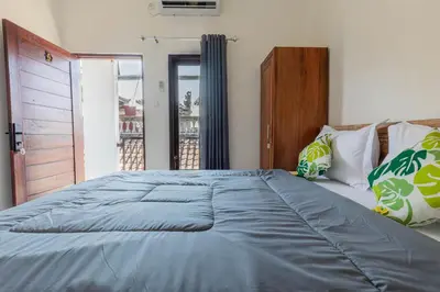 a bedroom with a large bed with a blue comforter at Bali DD homestay seminyak in Seminyak