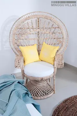 a wicker chair with two yellow pillows on it at 8BR Villa Mason - Minggu Villas in Seminyak