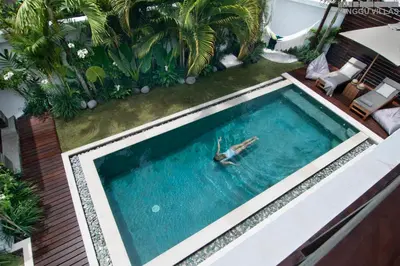 a swimming pool with a person in the water at 8BR Villa Mason - Minggu Villas in Seminyak