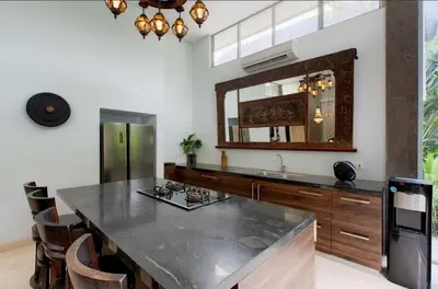 a kitchen with a large counter with a sink and a mirror at Villa Deh Simba at Seminyak Aramanis in Seminyak