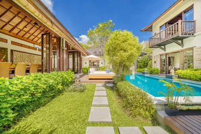 a backyard with a swimming pool and a house at Villa Jalamati in Seminyak