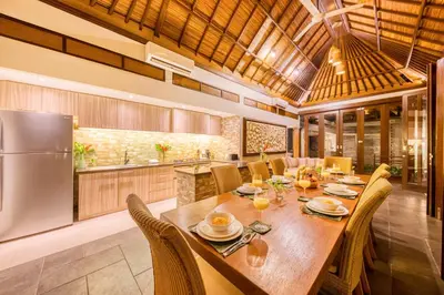 a kitchen with a large wooden table and chairs at Villa Jalamati in Seminyak