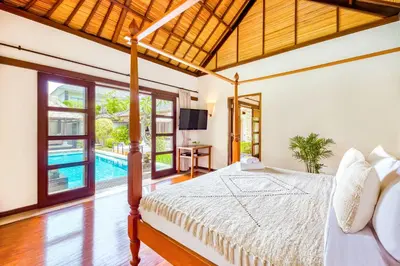 a bedroom with a bed and a swimming pool at Villa Jalamati in Seminyak