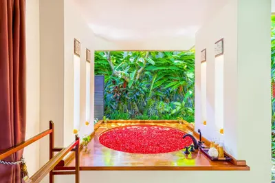 a red bath tub in a room with a window at Villa Jalamati in Seminyak