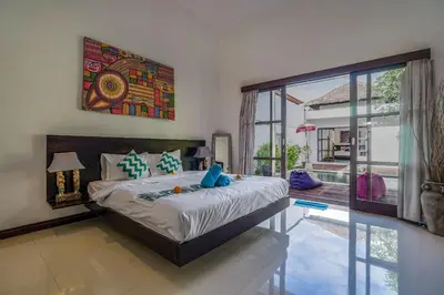 a bedroom with a king sized bed and a large window at Villa Art Gecko, 2BR private haven in Heart of Batu Belig, Seminyak in Canggu