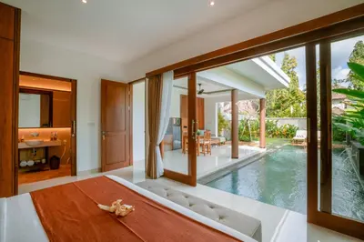a bedroom with a view of a swimming pool at Kahayana Seminyak Villa in Seminyak