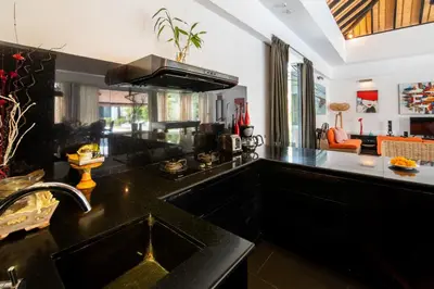 a kitchen with black counters and a black counter top at Villa Kalamansi Seminyak in Seminyak