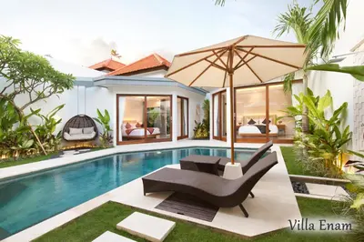a pool with a chair and an umbrella next to a house at Villa Mia Seminyak - Boutique Villas - II in Seminyak